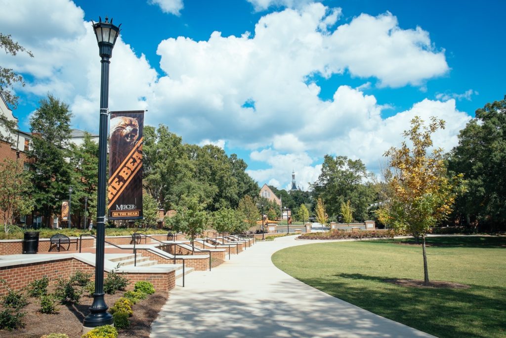 A sidewalk through Mercer's campus with a black and orange Mercer banner